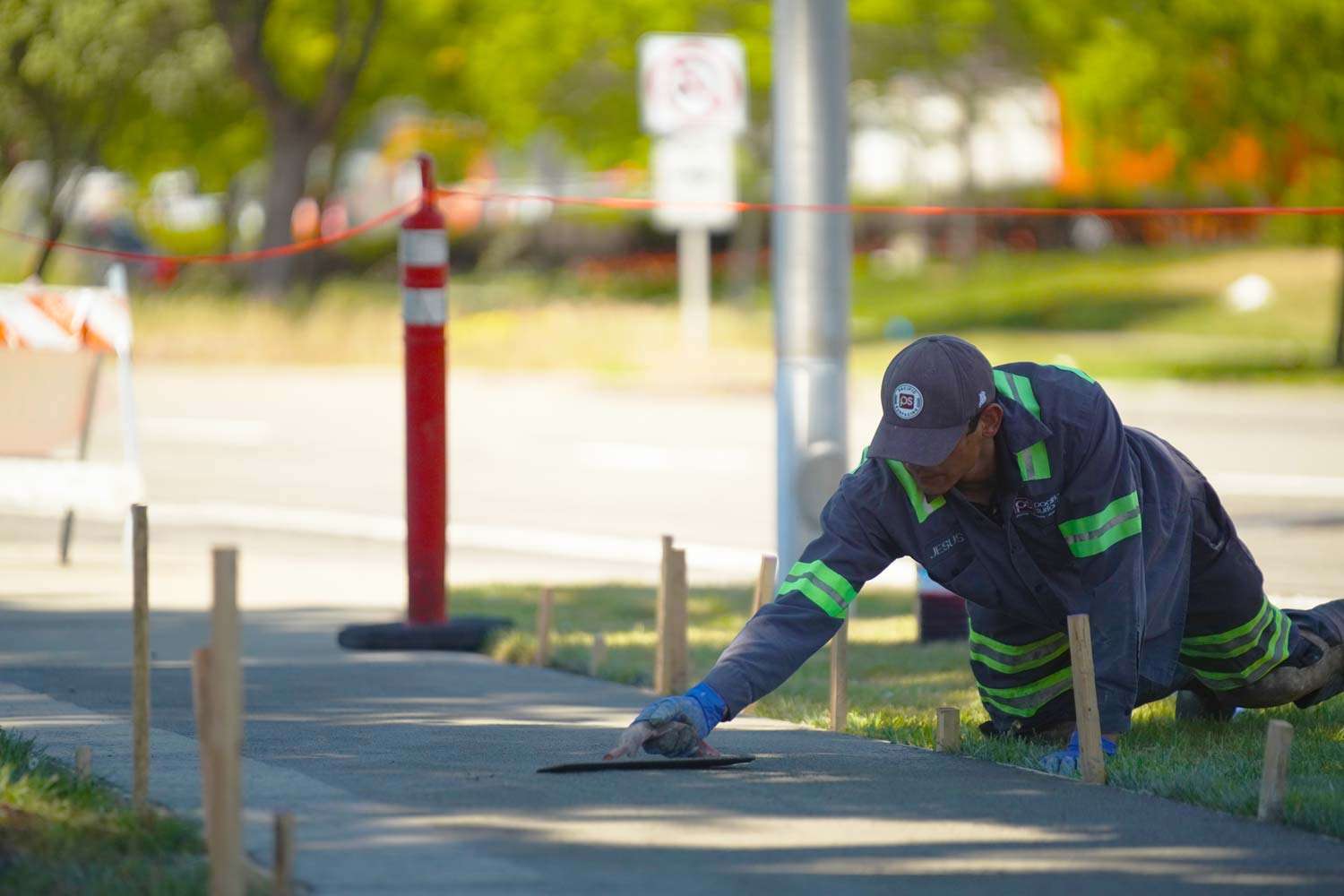 A Pacific Surfacing worker uses a trowel to finish a new section of concrete.
