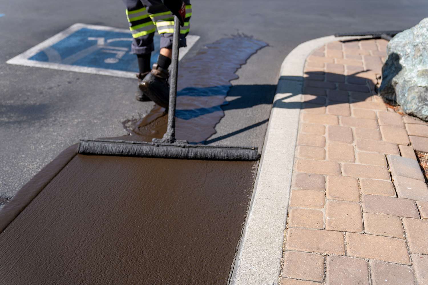 Crew member sealcoating a parking lot.