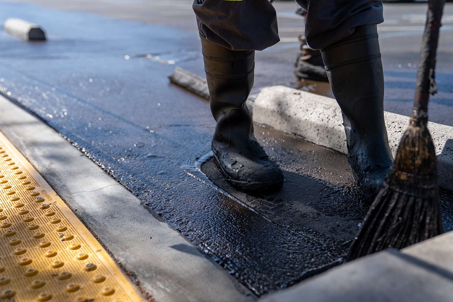 Crew member sealcoating parking spot.
