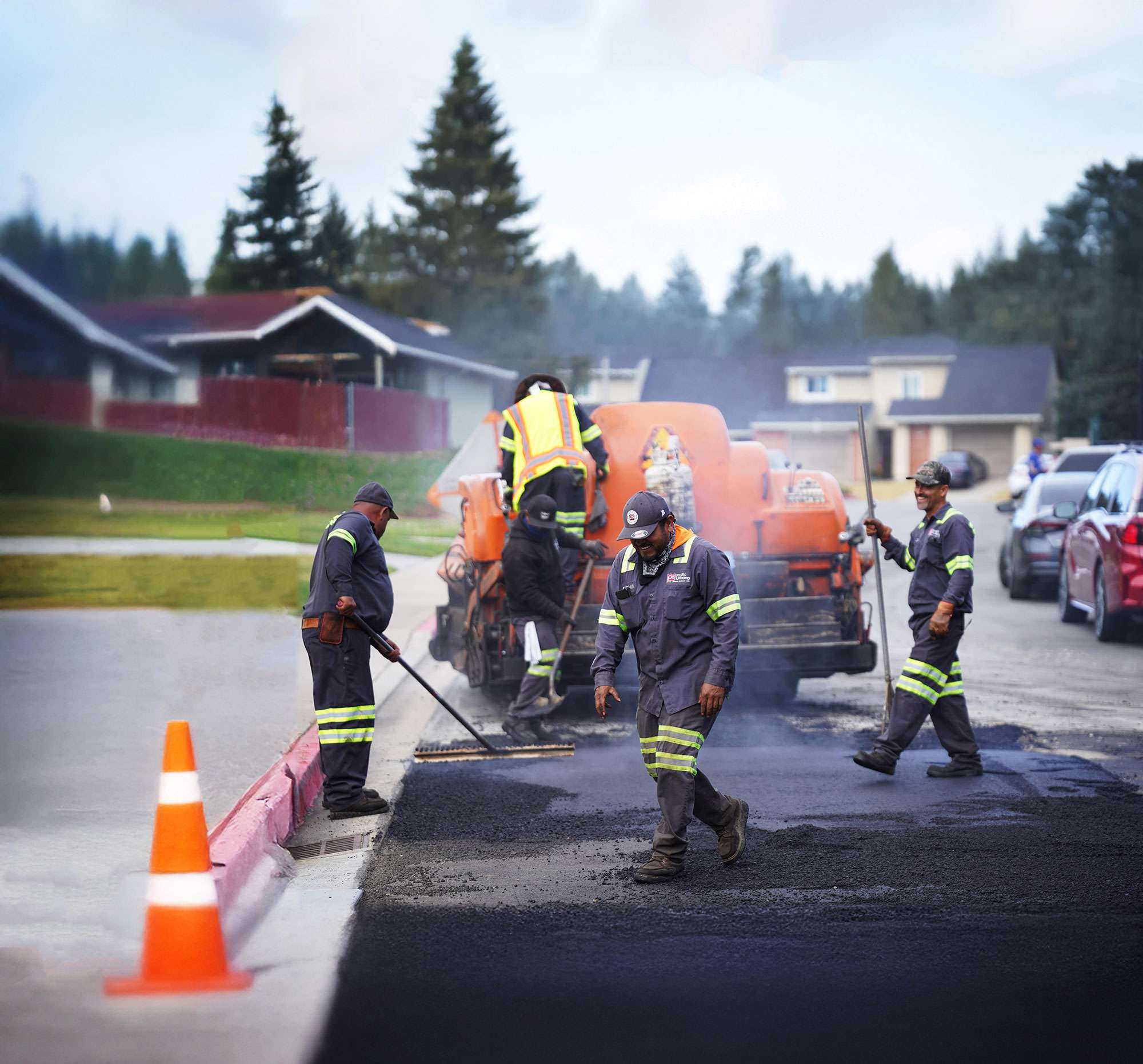 Pacific Surfacing crew members smiling and working together to pave asphalt.