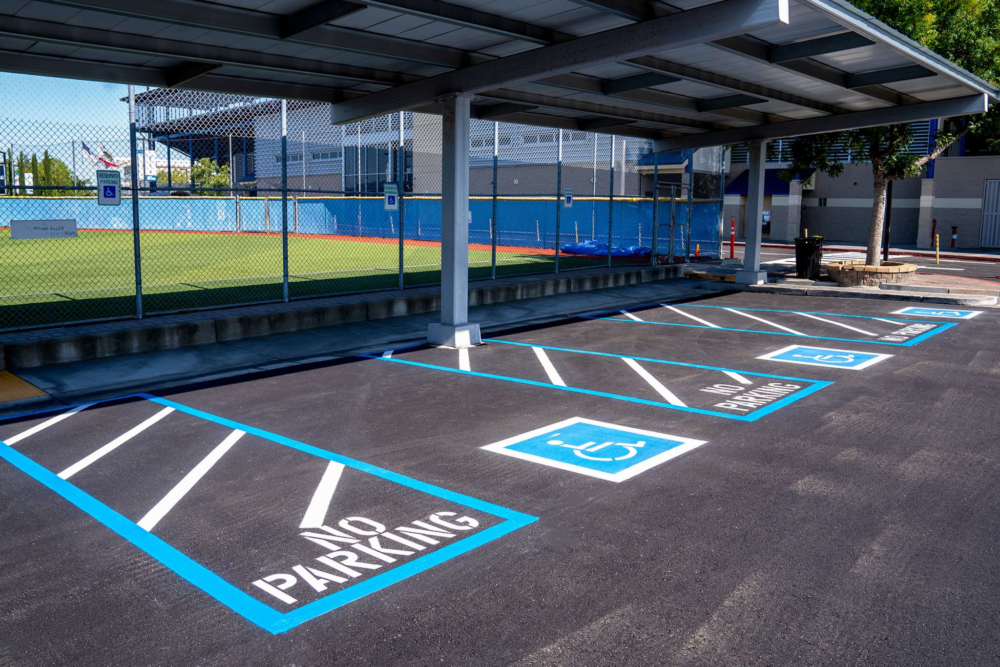 Freshly striped ADA parking spaces with blue striping in a paved lot by Pacific Surfacing