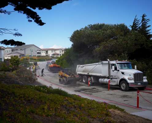 Pacific Surfacing completing commercial paving along a sloped neighborhood road.