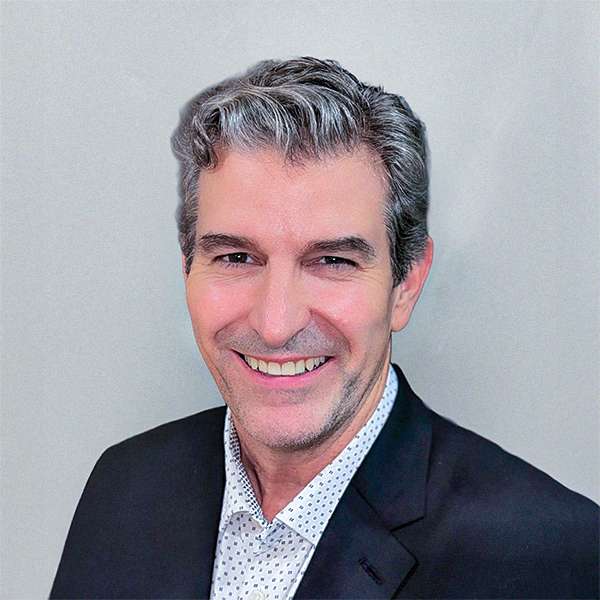Dan Fernandez, VP of Business Development, smiling in a suit against a gray background.